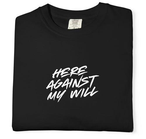 Black t-shirt with white text 'HERE AGAINST MY WILL' on a white background
